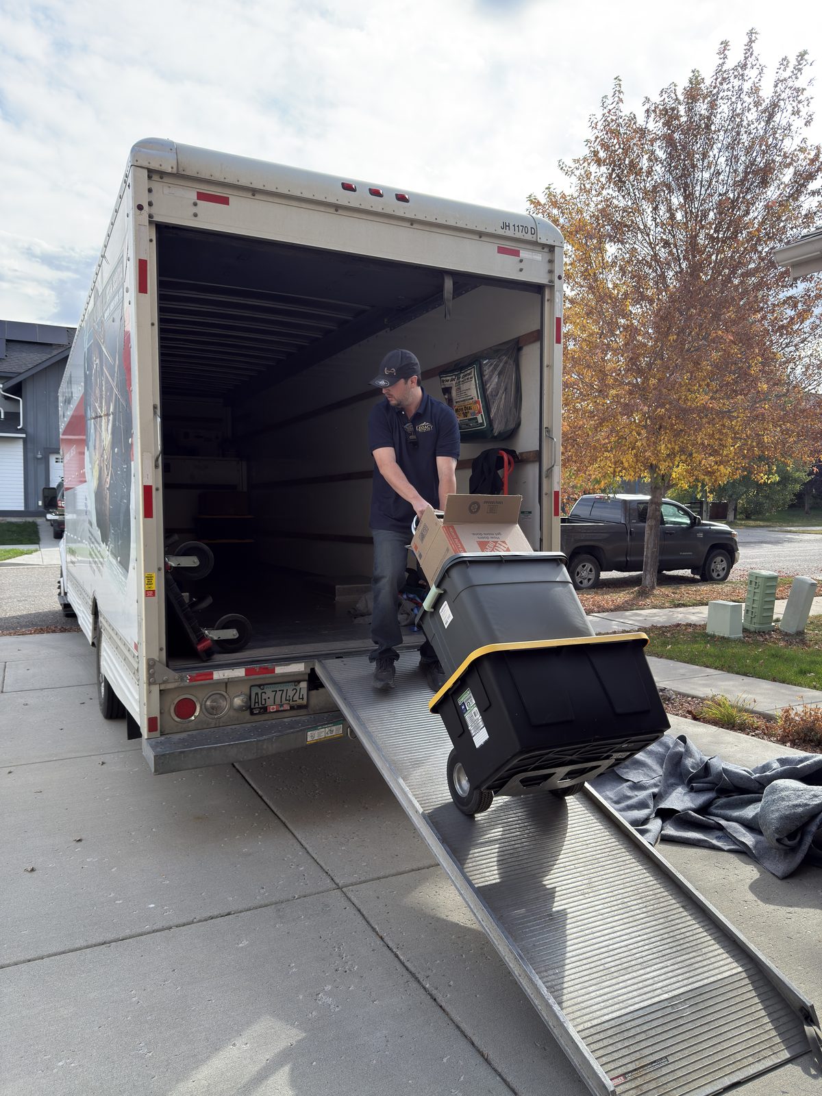 Legacy Moving Co. crew member wheeling boxes down a moving truck ramp during a residential move in Bozeman, Montana